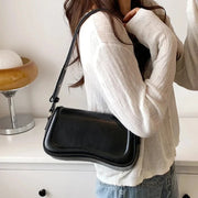 Amal - Handtasche mit gewellter Klappe – Schwarz